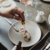 Faceless woman adding flavor on piece of toast